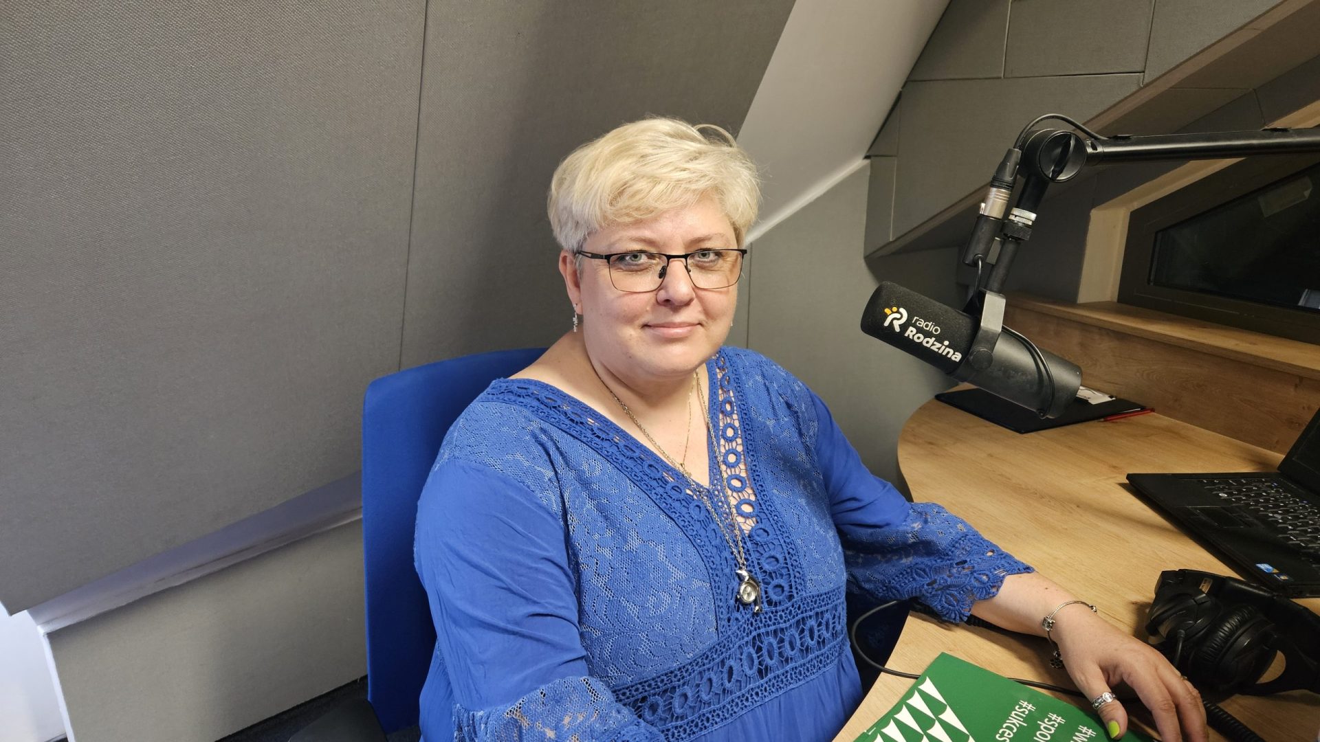 kobieta w niebieskiej sukni w studiu radiowym