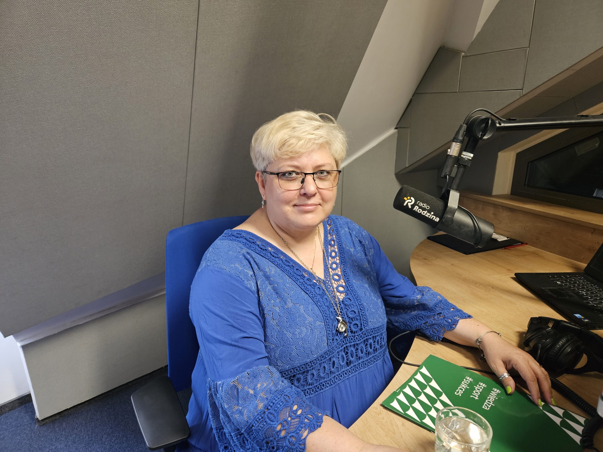 kobieta w niebieskiej sukni w studiu radiowym