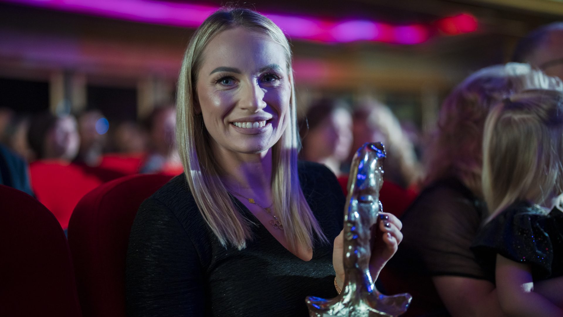 kobieta ze statuetka w dłoniach