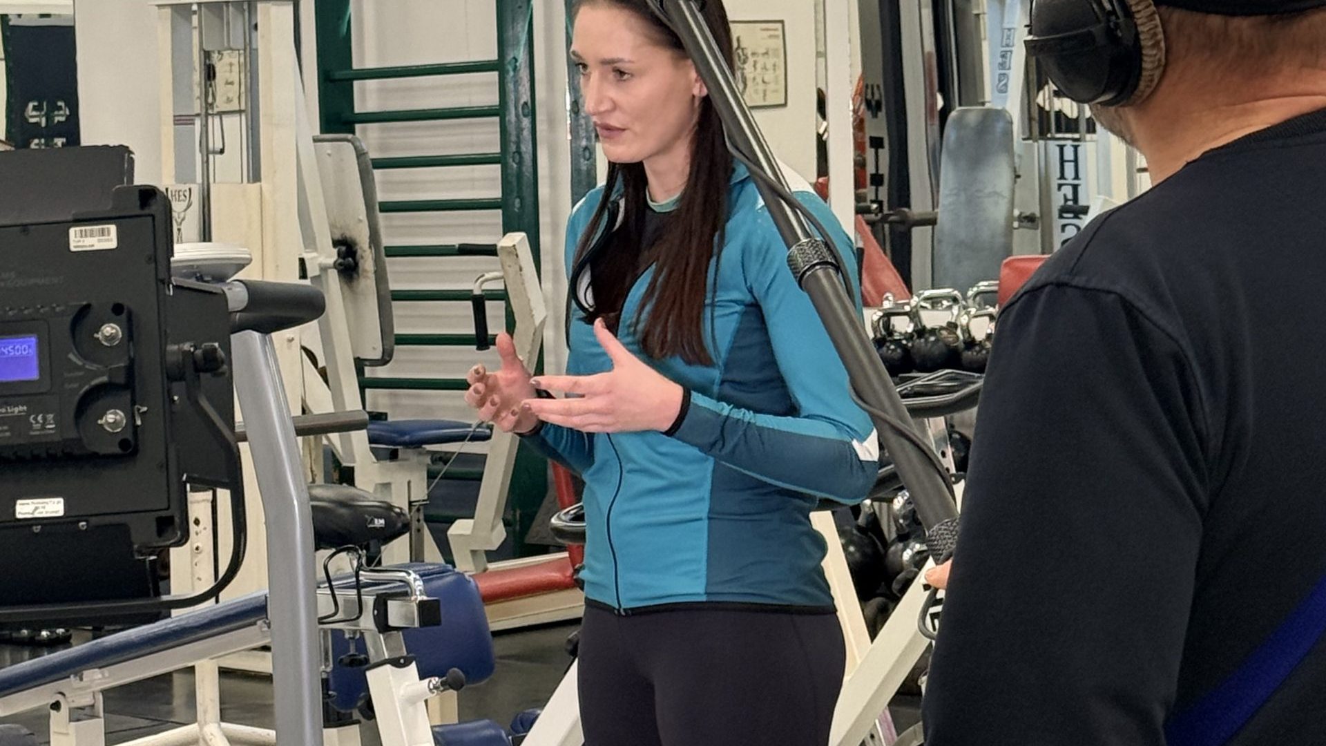 Kobieta w stroju sportowym w siłowni przed kamerą