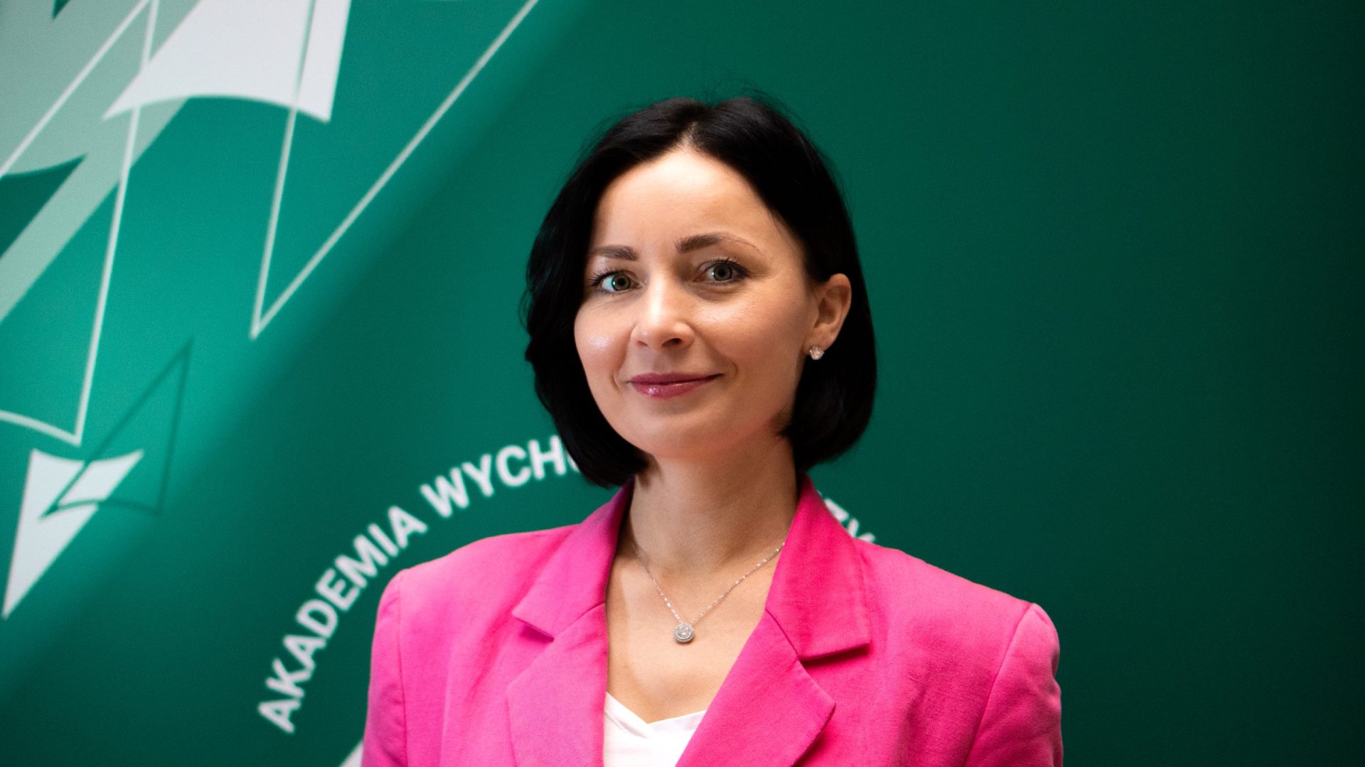 kobieta w różowej marynarce na zielonym tle