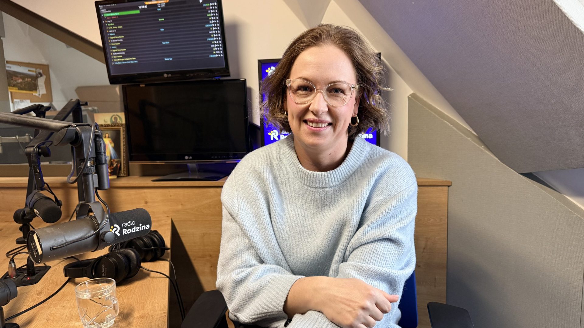 kobieta w niebieskim swetrze w studiu radiowym