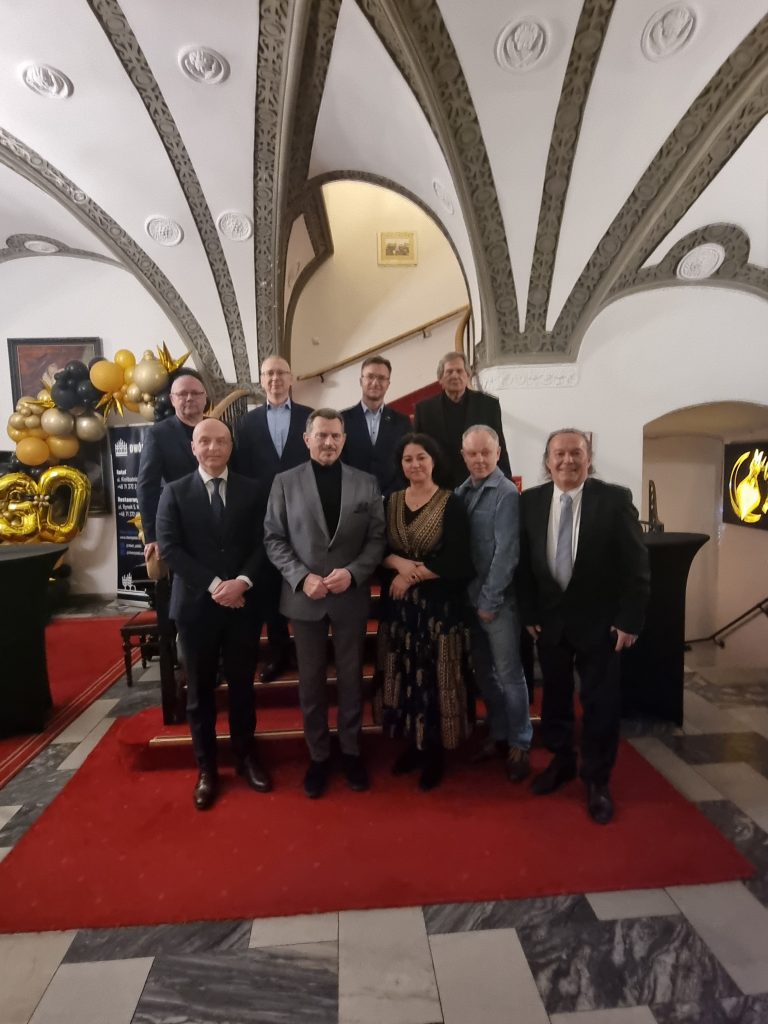 grupa osób na czerwonym dywanie pozująca do zdjęcia