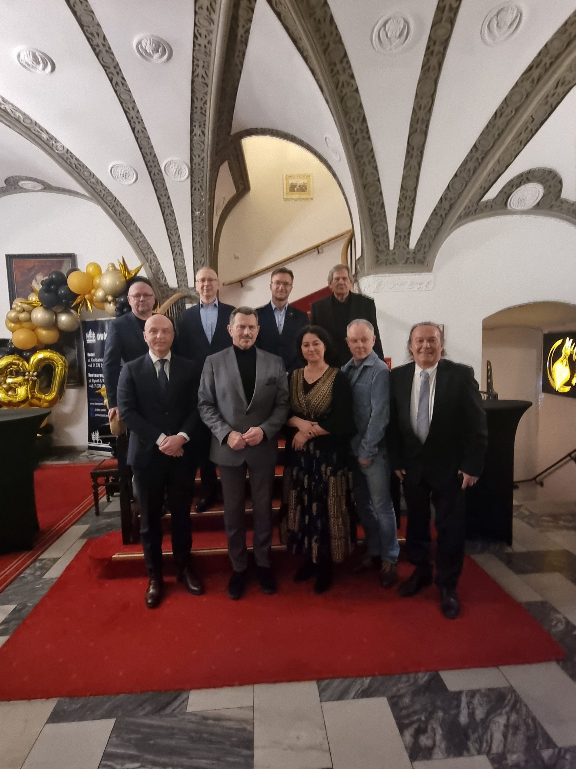 grupa osób na czerwonym dywanie pozująca do zdjęcia