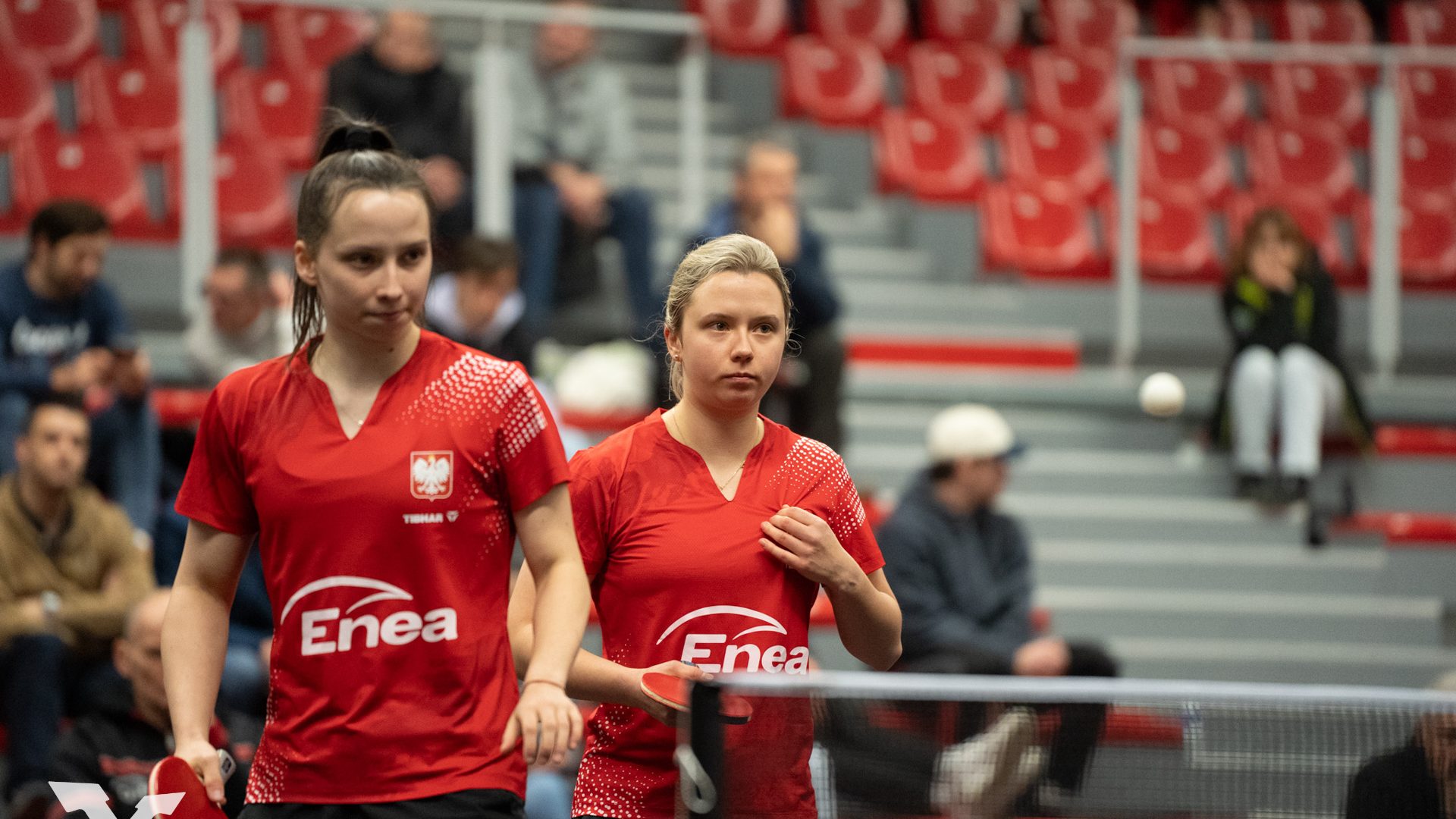 dwie kobiety w czerwonych strojach sportowych w hali sportowej