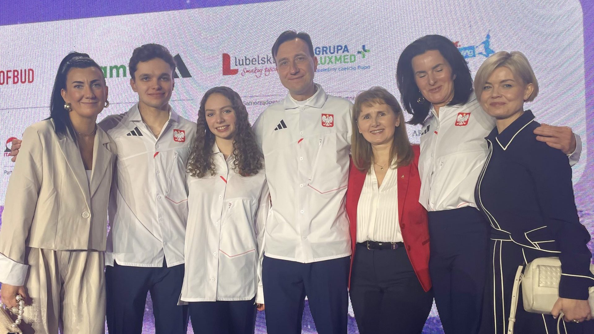 kilka osób na tle ścianki Komitetu Olimpijskiego