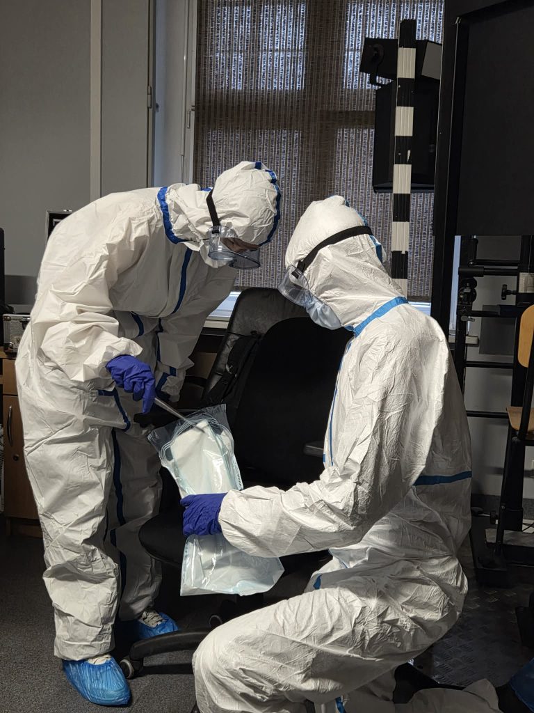 dwie osoby w fartuchach kryminalistycznych