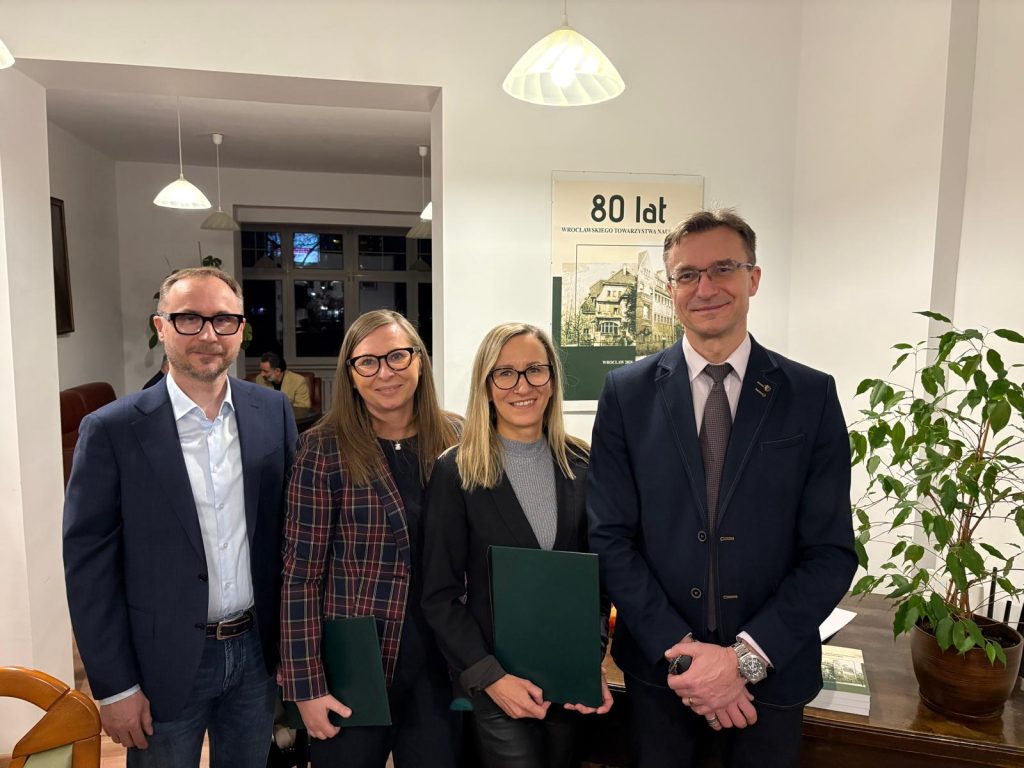 kilka osób pozujących do zdjęcia, trzech mężczyzn i kobieta