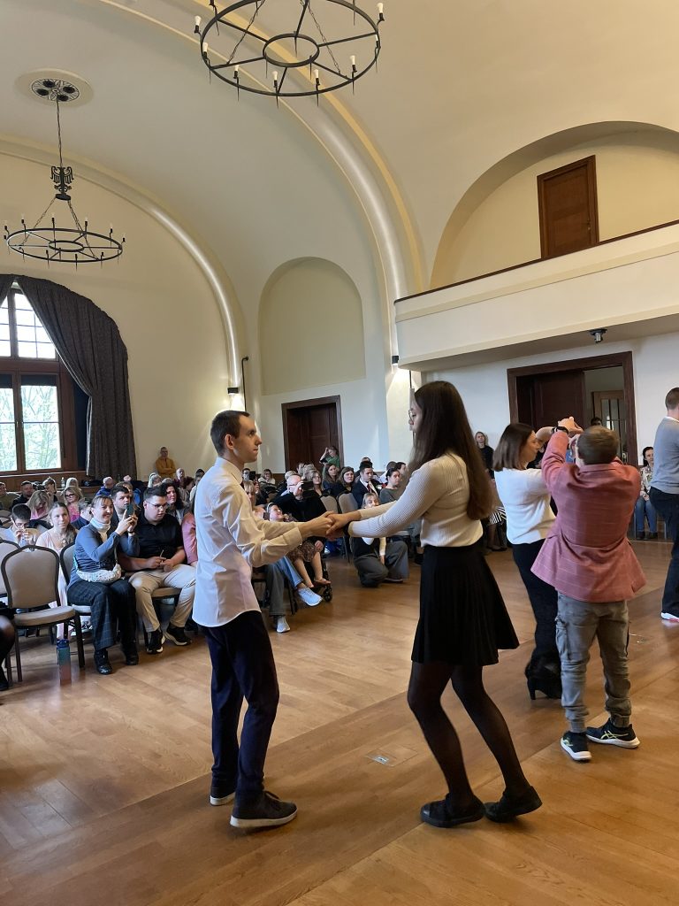 sala, tańczący w parach młodzi ludzie